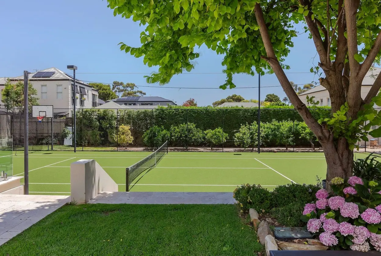 Backyard with a tennis court of Elite Accommodation property.